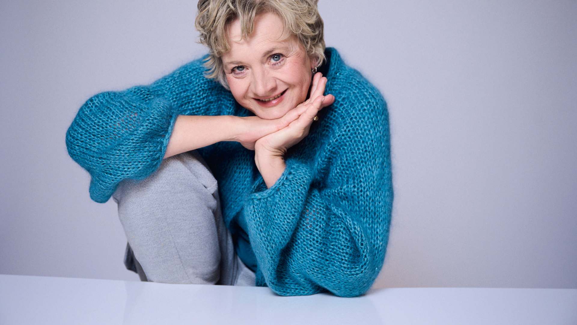 Astrid Zand mit aufgestützten Kopf sitzend